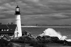 Waves Crash By Portland Light as Sun Breaks Through Clouds -BW